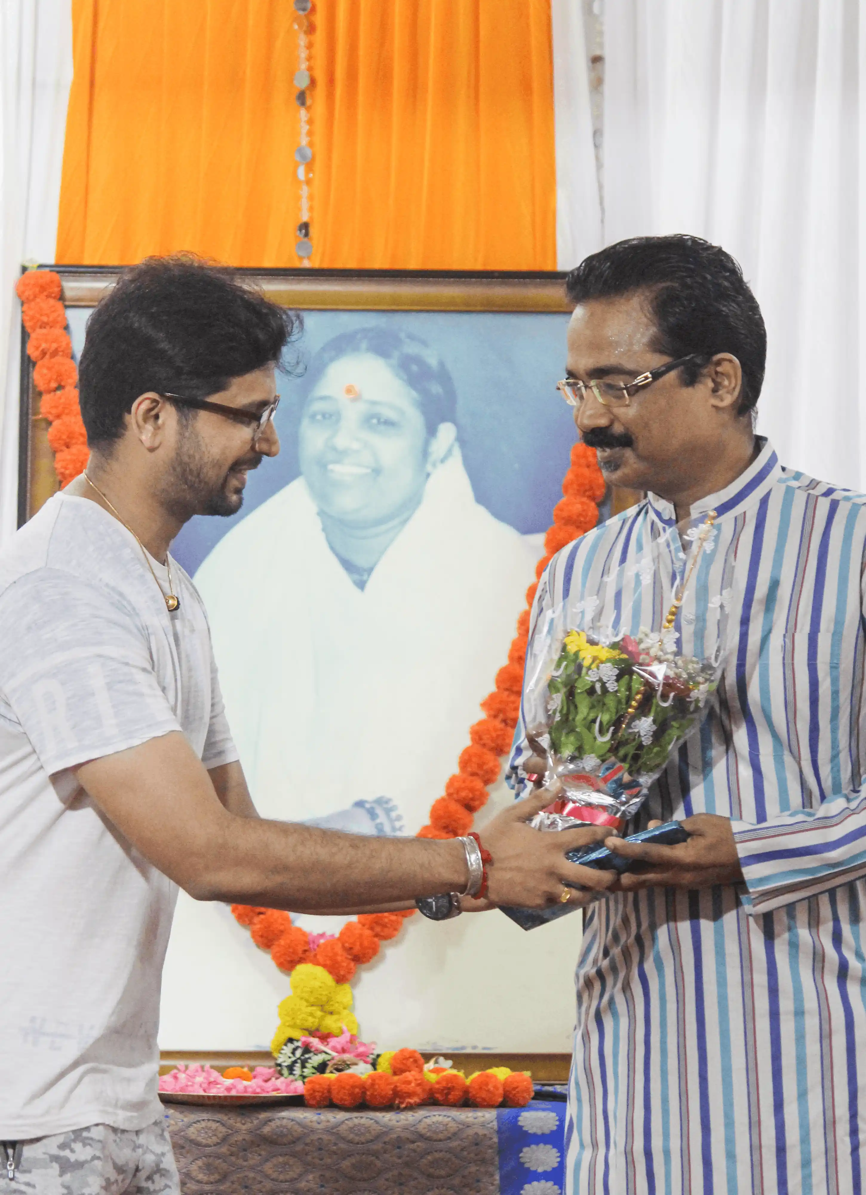 Two men exchanging a bouquet at a yoga community event